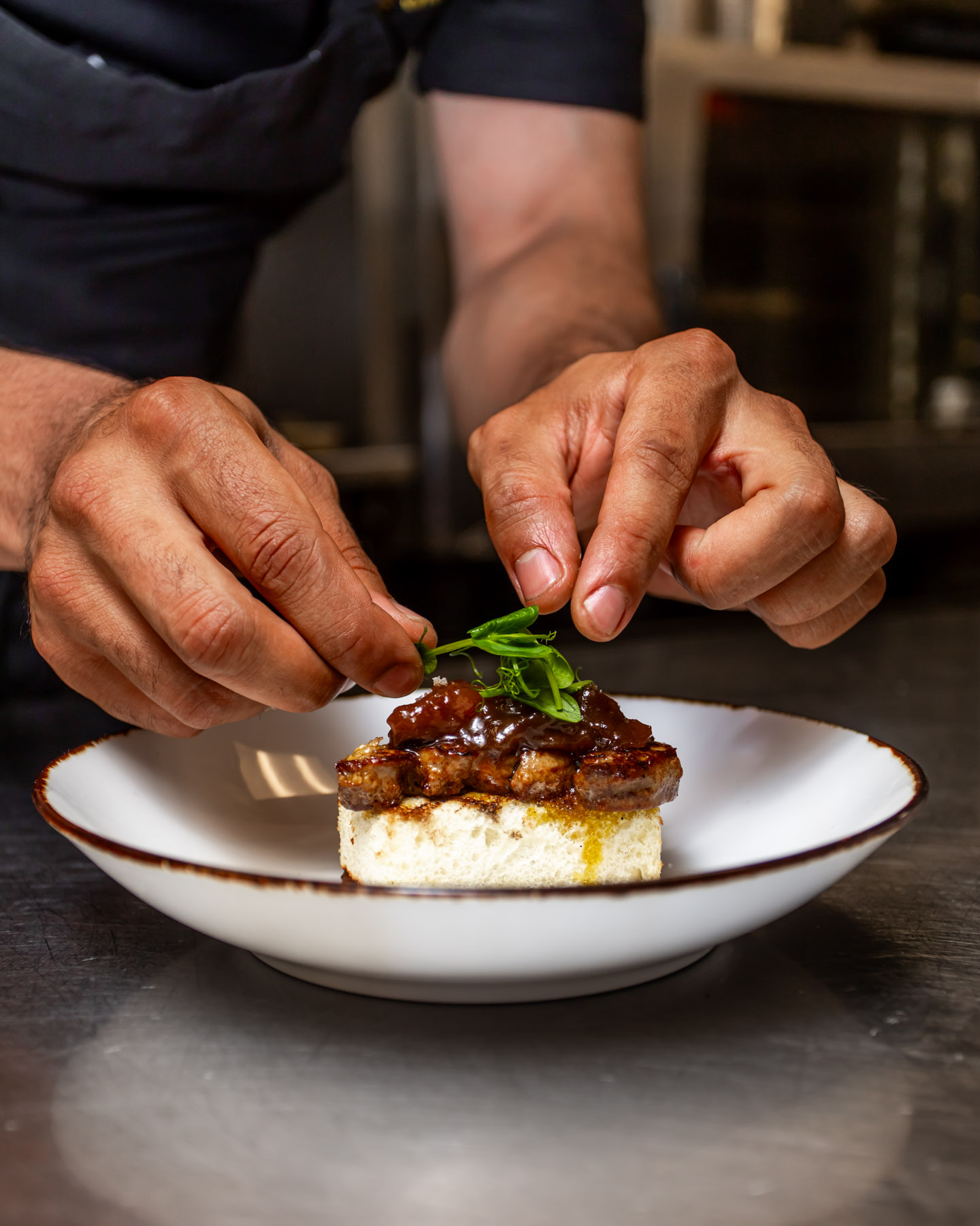 Chef preparing a gourmet plate at Osco! restaurant, InterContinental Montréal