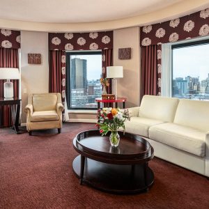 Salon élégant de la Suite Tourelles de L'interContinetal avec vue panoramique sur Montréal