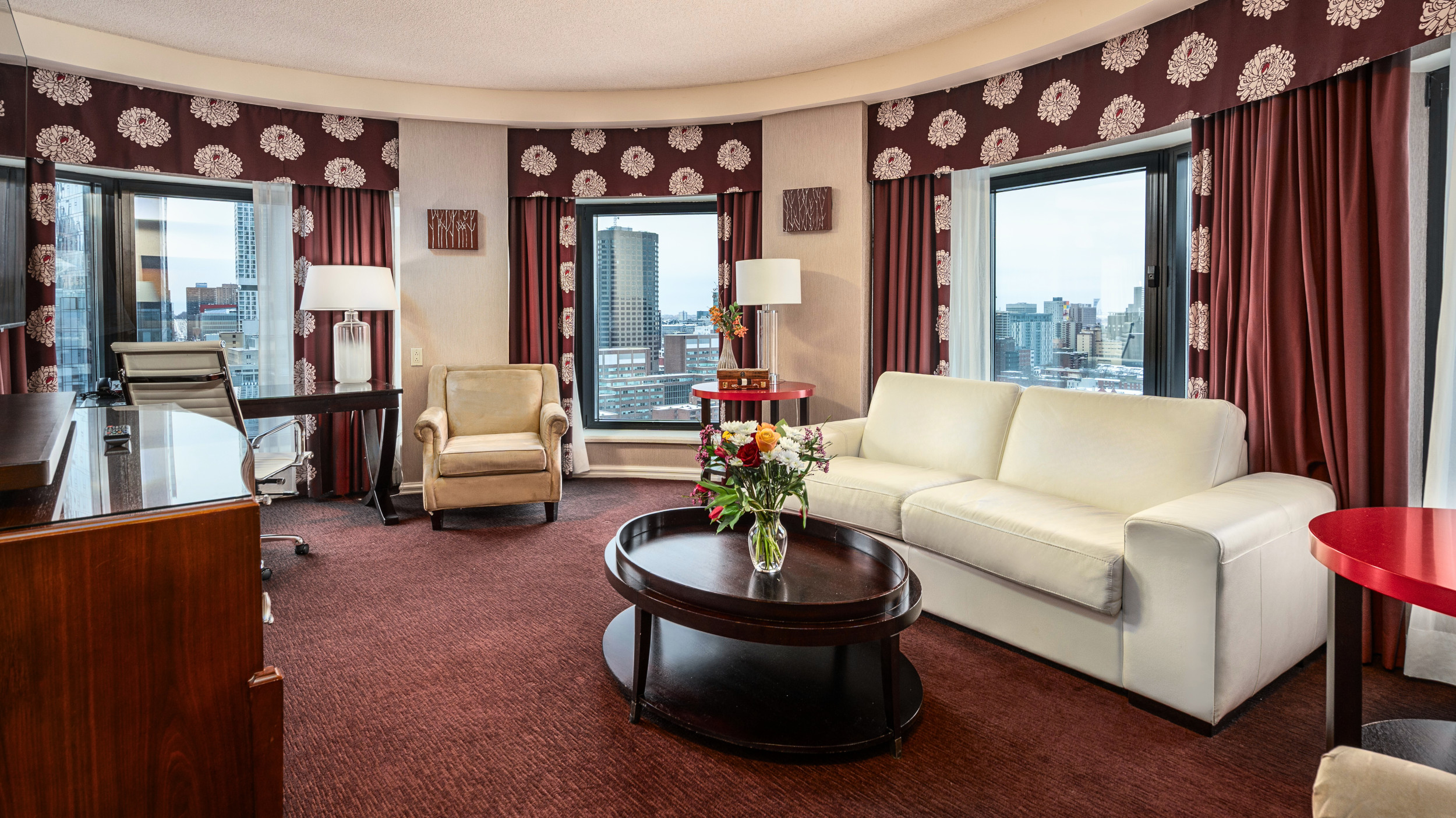 Salon élégant de la Suite Tourelles de L'interContinetal avec vue panoramique sur Montréal